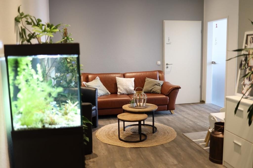 Empfangsbereich mit Ledersofa, Aquarium und Pflanzen