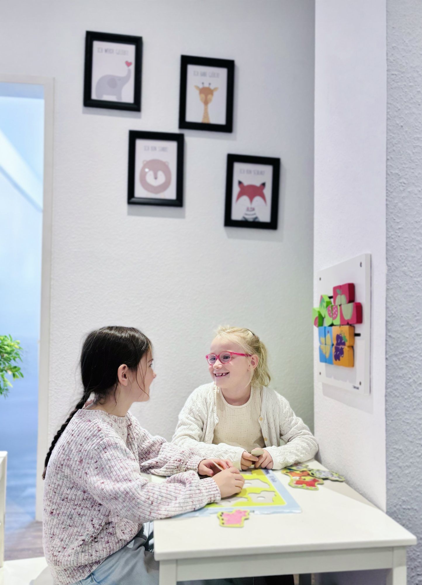 Zwei Kinder malen am Kindertisch im Wartezimmer der Praxis